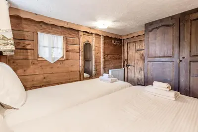 two beds in a room with wooden walls at Le Gite - Le Mont d'Arbois - 5 pax in Saint-Gervais-les-Bains