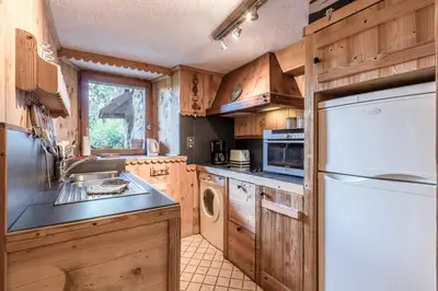 a kitchen with wooden cabinets and a white refrigerator at Le Gite - Le Mont d'Arbois - 5 pax in Saint-Gervais-les-Bains