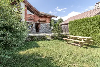 a wooden bench sitting in the grass in front of a building at Le Gite - Le Mont d'Arbois - 5 pax in Saint-Gervais-les-Bains