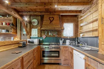 a kitchen with wooden cabinets and a stove at Le Gite - L'oréade - 6 pax in Saint-Gervais-les-Bains