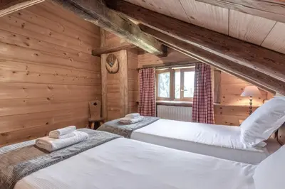 two beds in a room with wooden walls at Le Gite - L'oréade - 6 pax in Saint-Gervais-les-Bains