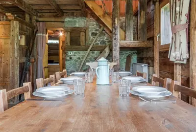 a long wooden table with plates and glasses on it at Le Gite - L'oréade - 6 pax in Saint-Gervais-les-Bains