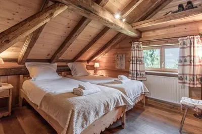 two beds in a room with wooden ceilings at Le Gite - L'oréade - 6 pax in Saint-Gervais-les-Bains