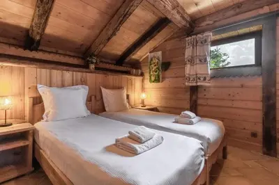 a bedroom with two beds in a wooden cabin at Le Gite - Le Mont Blanc - 9 pax in Saint-Gervais-les-Bains
