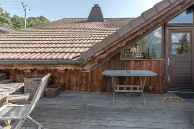 a house with a wooden deck with a roof at Le Gite - Le Mont Blanc - 9 pax in Saint-Gervais-les-Bains