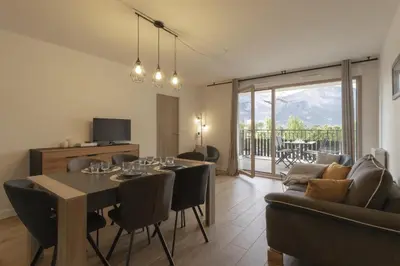 a living room with a dining room table and a couch at Le 201 - Proche Centre Ville - Ski In - Ski Out in Saint-Gervais-les-Bains