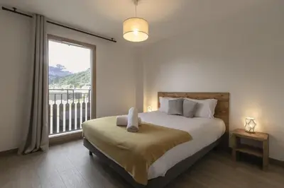 a bedroom with a bed and a large window at Le 201 - Proche Centre Ville - Ski In - Ski Out in Saint-Gervais-les-Bains