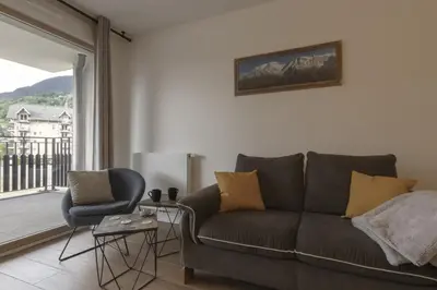 a living room with a couch and a chair and a window at Le 201 - Proche Centre Ville - Ski In - Ski Out in Saint-Gervais-les-Bains