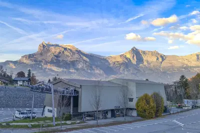 a large building with a mountain in the background at Le 201 - Proche Centre Ville - Ski In - Ski Out in Saint-Gervais-les-Bains