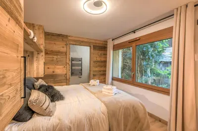 a bedroom with a bed and a large window at Appartement Capra - Welkeys in Megève
