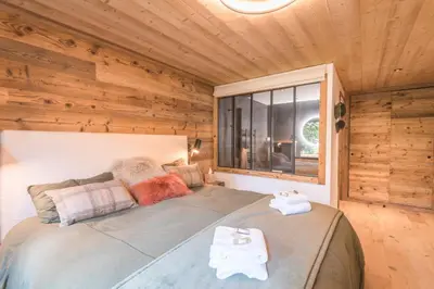 a bedroom with a large bed in a log cabin at Appartement Capra - Welkeys in Megève
