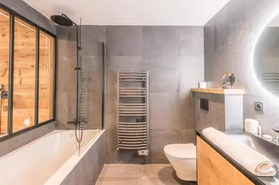 a bathroom with a tub and a toilet and a sink at Appartement Capra - Welkeys in Megève