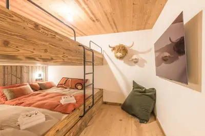 a bedroom with a bunk bed with horns on the wall at Appartement Capra - Welkeys in Megève