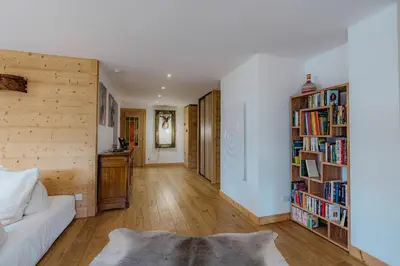 a living room with a white couch and bookshelves at Au pied du télécabine & gare St Gervais in Saint-Gervais-les-Bains