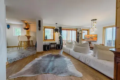 a living room with a white couch and a rug at Au pied du télécabine & gare St Gervais in Saint-Gervais-les-Bains