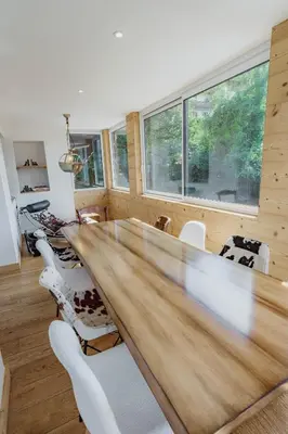 a large wooden table in a room with chairs at Au pied du télécabine & gare St Gervais in Saint-Gervais-les-Bains
