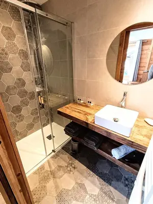 a bathroom with a sink and a shower at Chalet Josaly Jacuzzi et Sauna in Samoëns