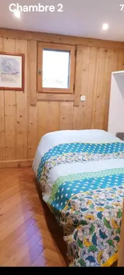 a bedroom with a bed in a room with a window at Mini Chalet vue montagne in Les Houches