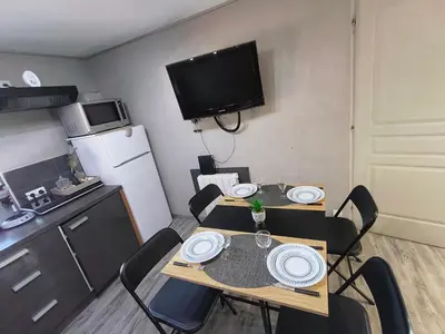 a small kitchen with a table and chairs in a room at Cosy F2 in Passy