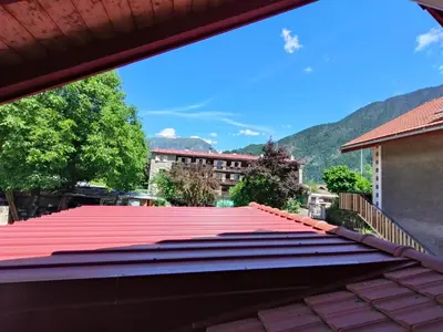 a red roof on a building with mountains in the background at Cosy F2 in Passy