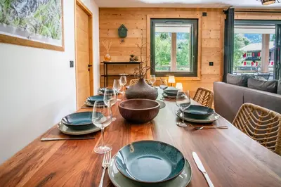 a dining room table with plates and wine glasses at La terrasse des Aiguilles - Magnifiques vues in Les Houches