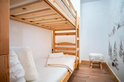 a small room with a bunk bed and a chair at La terrasse des Aiguilles - Magnifiques vues in Les Houches