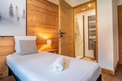 a bedroom with a white bed and a shower at La terrasse des Aiguilles - Magnifiques vues in Les Houches