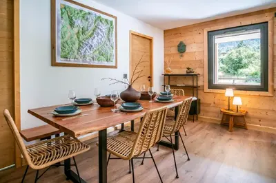 a dining room with a wooden table and chairs at La terrasse des Aiguilles - Magnifiques vues in Les Houches
