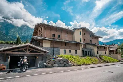 a person on a motorcycle parked in front of a building at La terrasse des Aiguilles - Magnifiques vues in Les Houches