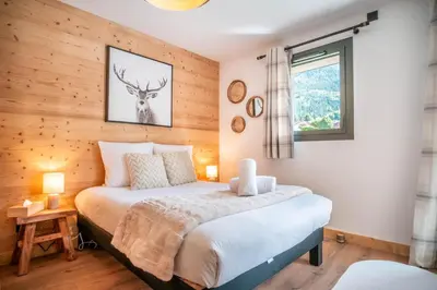a bedroom with a bed with a deer picture on the wall at La terrasse des Aiguilles - Magnifiques vues in Les Houches