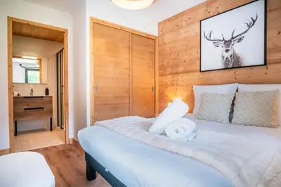 a bedroom with a bed with a deer picture on the wall at La terrasse des Aiguilles - Magnifiques vues in Les Houches