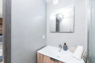 a white bathroom with a sink and a mirror at Chaleureux Chalet Familial - Vue époustouflante in Combloux