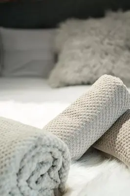 a close up of a blanket on a bed at Chaleureux Chalet Familial - Vue époustouflante in Combloux