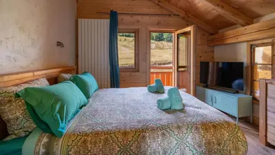 a bedroom with a bed and a television in a cabin at Chalet Vallée de Chamonix, Ski, Snow, Spa vue MontBlanc by ImmoConciergerie in Saint-Gervais-les-Bains