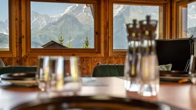 a table in a restaurant with a view of mountains at Chalet Vallée de Chamonix, Ski, Snow, Spa vue MontBlanc by ImmoConciergerie in Saint-Gervais-les-Bains