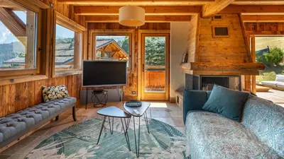 a living room with a couch and a tv at Chalet Vallée de Chamonix, Ski, Snow, Spa vue MontBlanc by ImmoConciergerie in Saint-Gervais-les-Bains