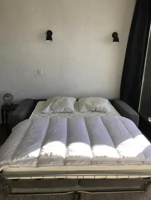 a bed in a room with two pillows on it at Appartement à 20m des pistes, avec piscine et sauna in Arâches-la-Frasse