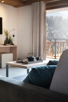 a kitchen and living room with a table and chairs at MGM Hôtels & Résidences - Hôtel Laska in Les Contamines-Montjoie