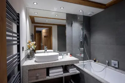 a bathroom with a sink and a glass shower at MGM Hôtels & Résidences - Hôtel Laska in Les Contamines-Montjoie