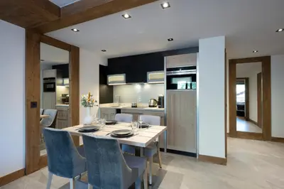 a kitchen and dining room with a table and chairs at MGM Hôtels & Résidences - Hôtel Laska in Les Contamines-Montjoie