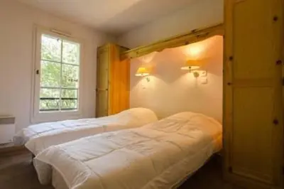 a bedroom with two beds and a window at Grand Panorama 216 - 2 bed Apt, next to Bettex lift, sleeps 6 in Saint-Gervais-les-Bains