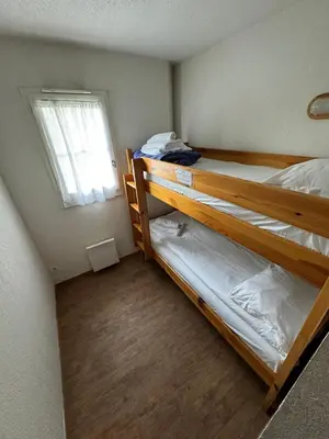 two bunk beds in a small room with a window at Grand Panorama 216 - 2 bed Apt, next to Bettex lift, sleeps 6 in Saint-Gervais-les-Bains