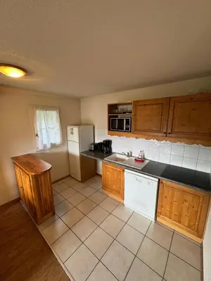 a kitchen with wooden cabinets and a white refrigerator at Grand Panorama 216 - 2 bed Apt, next to Bettex lift, sleeps 6 in Saint-Gervais-les-Bains