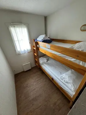 two bunk beds in a small room with a window at Grand Panorama 216 - 2 bed Apt, next to Bettex lift, sleeps 6 in Saint-Gervais-les-Bains