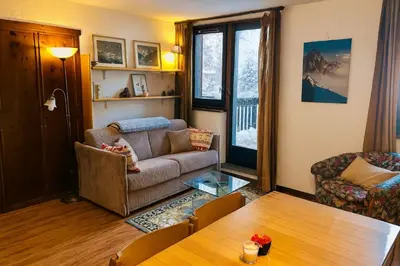 a living room with a couch and a table at Beautiful T2 with balcony near track in Chamonix-Mont-Blanc