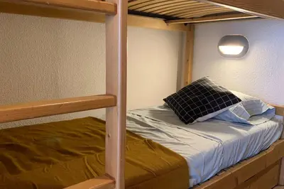 a bunk bed with a pillow on top of it at Appartement vue Montblanc 5mn piste2 in Les Trabets