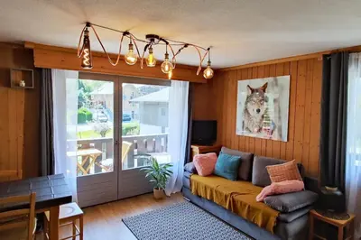 a living room with a couch and a window at Appartement vue Montblanc 5mn piste2 in Les Trabets