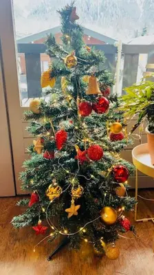 a christmas tree sitting on the floor in a room at Appartement vue Montblanc 5mn piste2 in Les Trabets