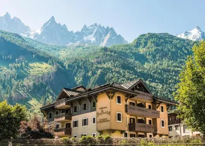 a building with mountains in the background at La Ginabelle – vue Mont Blanc avec piscine in Chamonix-Mont-Blanc