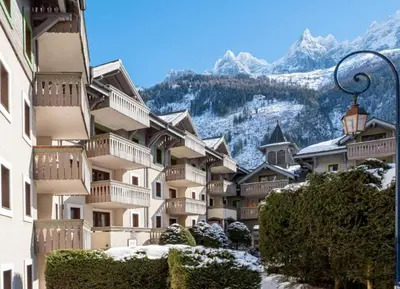 a group of buildings with mountains in the background at La Ginabelle – vue Mont Blanc avec piscine in Chamonix-Mont-Blanc